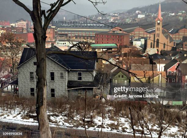 Wide view of Johnstown cityscape with houses, a church, and mountains in the distance, Johnstown, Pennsylvania, 1983.