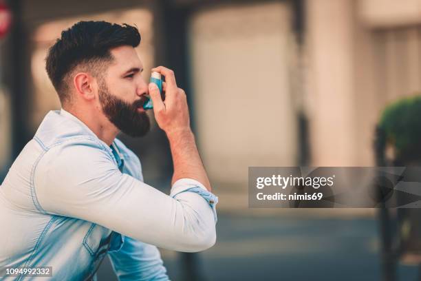 men using asthma inhaler outdoor - inhaler stock pictures, royalty-free photos & images