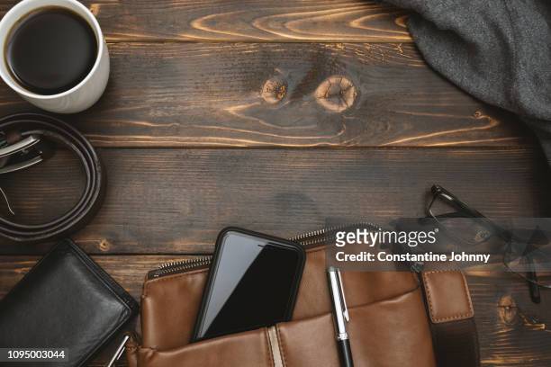 men's satchel bags, mobile phone and male personal belongings on rustic wood - flatlay fashion stockfoto's en -beelden