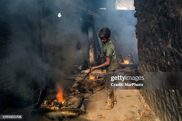 Shihab works in a metal shop near shipyard where he breaks metal small pieces and puts them into the furnace. Dhaka, Bangladesh, February 7, 2019