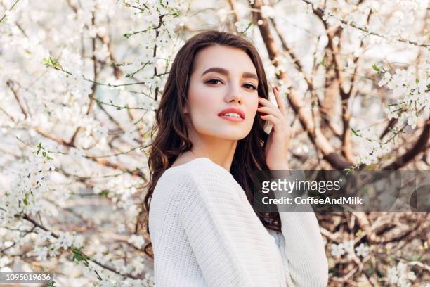 hermosa chica en el fondo de bush de primavera - blossom fotografías e imágenes de stock