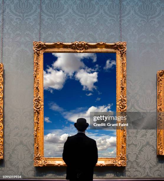 man looking at framed photograph. - painting frame stock-fotos und bilder