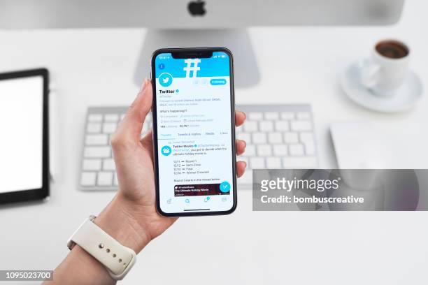 twitter-profil auf dem apple iphone x - man texting stock-fotos und bilder