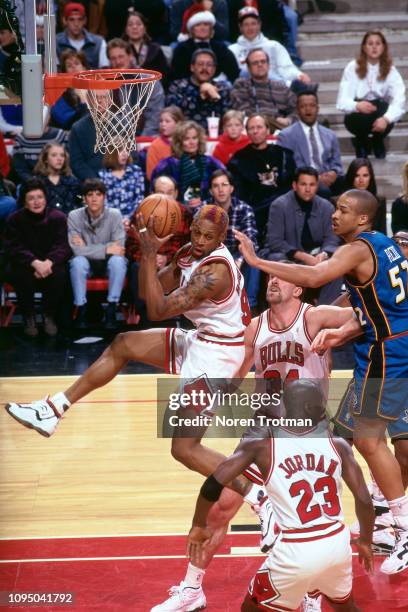 Detroit Pistons player Dennis Rodman rebounds the ball against the
