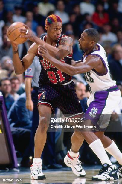 Dennis Rodman of the Chicago Bulls handles the ball against Glenn Robinson of the Milwaukee Bucks on December 3, 1996 at the Bradley Center in...
