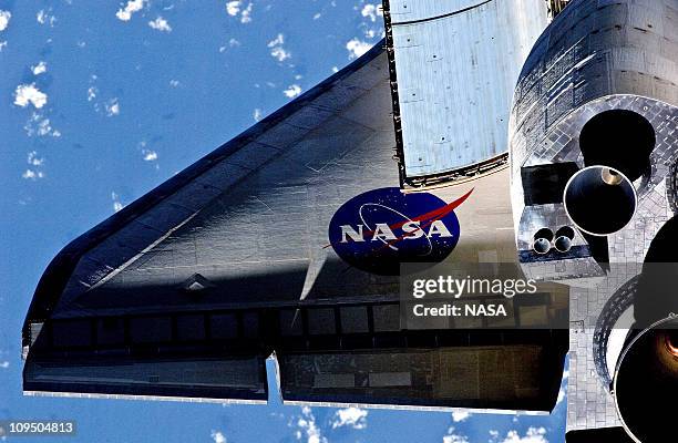 In this handout image provided by NASA, partial view of the port wing of the space shuttle Discovery during a survey of the approaching STS-133...