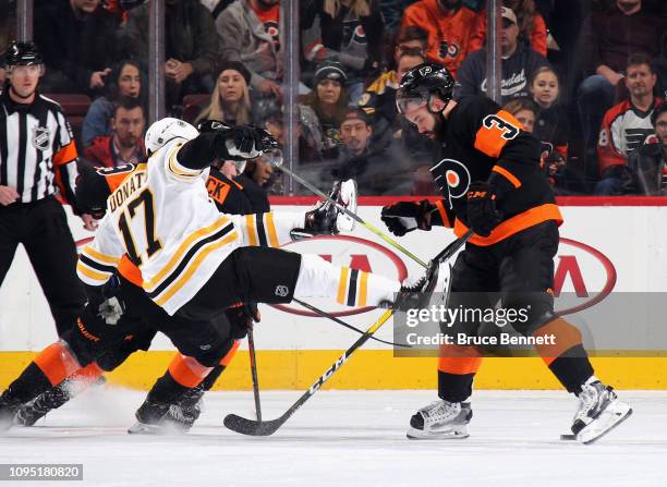 Radko Gudas of the Philadelphia Flyers checks Ryan Donato of the Boston Bruins during the second period at the Wells Fargo Center on January 16, 2019...