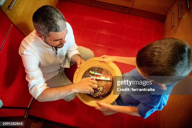 family celebrating a birthday - birthday cake overhead stock pictures, royalty-free photos & images