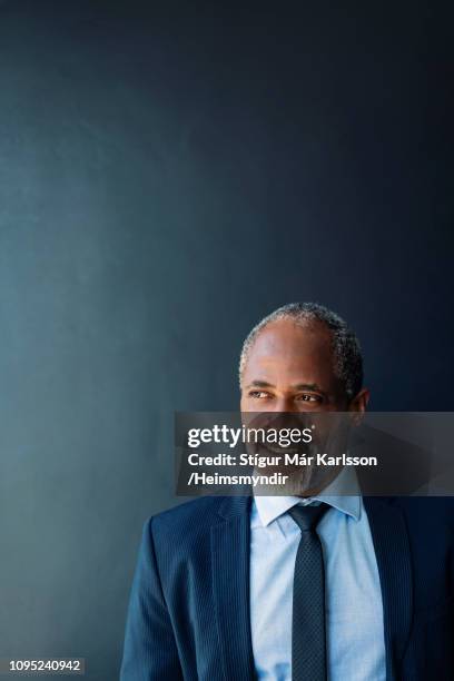 close-up of thoughtful businessman against wall - african american man day dreaming stock pictures, royalty-free photos & images