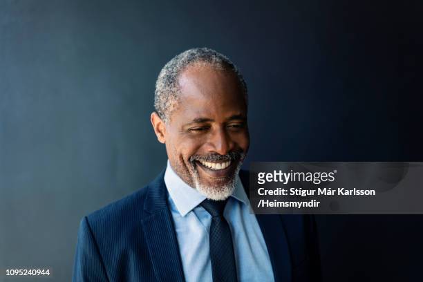close-up van zakenman glimlachend tegen muur - black suit stockfoto's en -beelden