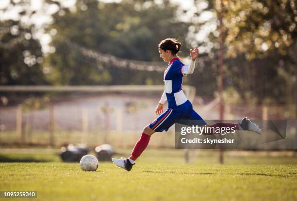 teenage soccer player about to kick the ball during the match. - girl kicking stock pictures, royalty-free photos & images