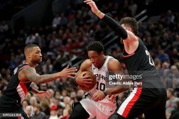 DeMar DeRozan of the San Antonio Spurs works against Damian Lillard and Jusuf Nurkic of the Portland Trail Blazers in the first quarter during their...