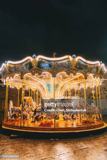karussell in der nacht auf weihnachtsmarkt - carousel horses stock-fotos und bilder