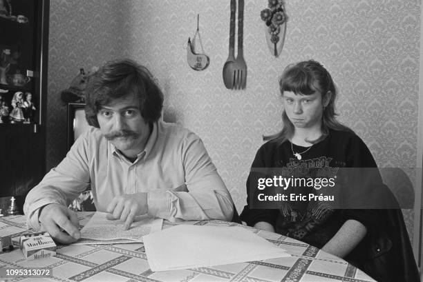 Bernard Laroche, seated next to his sister-in-law, Murielle Bolle, reviews the court transcription of Bolle's verbal testimony. Bernard Laroche is...