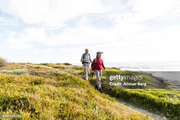 senior couple hiking - woman on walking in countryside stock-fotos und bilder