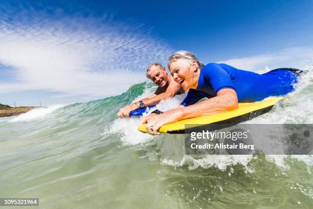 senior couple bodyboarding together - adrenaline bildbanksfoton och bilder