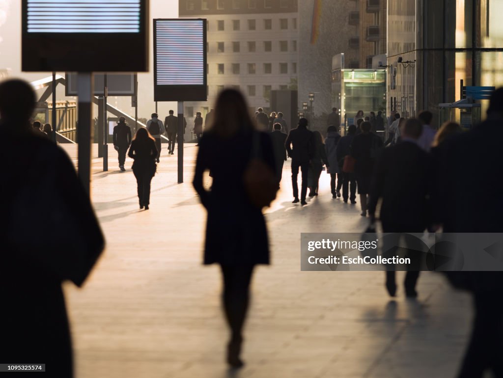 Silhouette of businesswoman among other commuters at modern business district