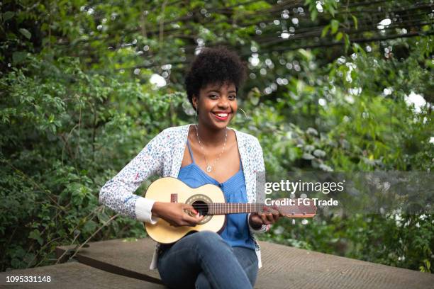 hispanic-latino joven afro tocando guitarra - samba fotografías e imágenes de stock