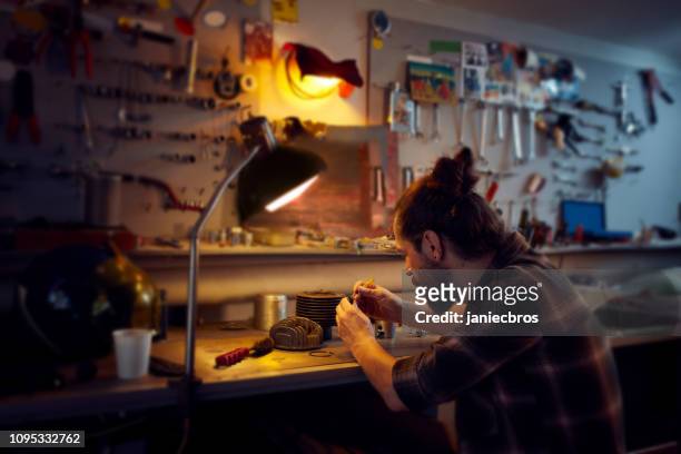 young man in workshop cleaning moto piston - motocross gear stock pictures, royalty-free photos & images