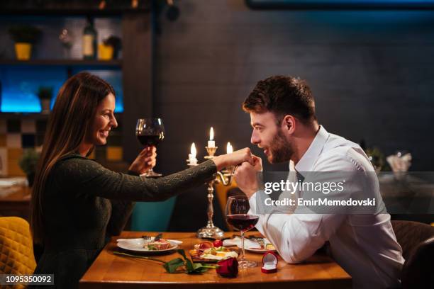 paar beim romantischen abendessen in einem restaurant - gallanterie stock-fotos und bilder