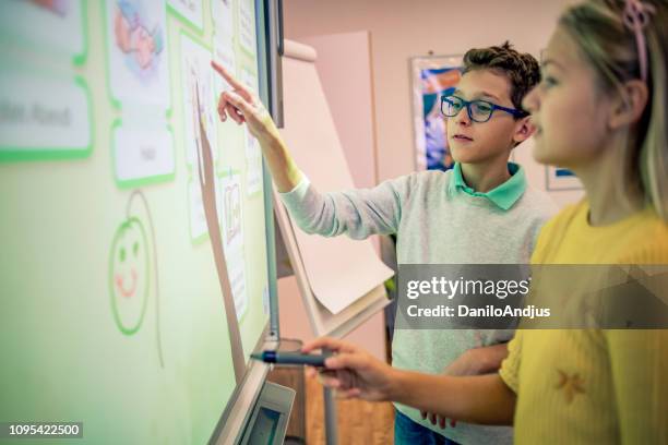 vrienden van de school werken samen aan een project - interactief stockfoto's en -beelden