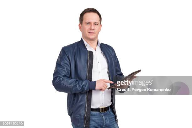 portrait of a young man in blue leather jacket holding digital tablet and looking at camera over white background"n - レザージャケット ストックフォトと画像
