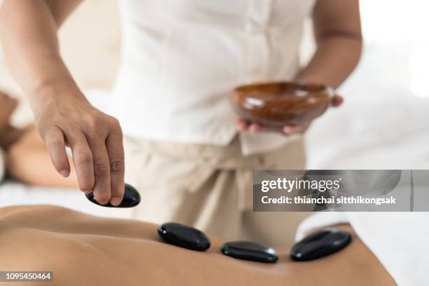 hot stone massage therapy - terapia lastone fotografías e imágenes de stock