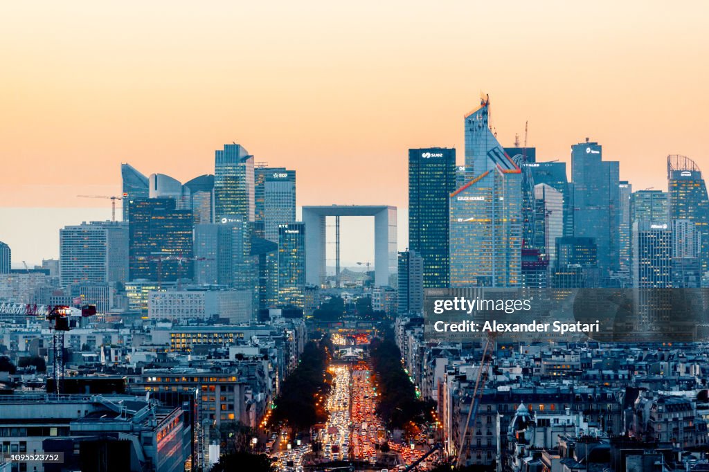Elevated view of illuminated skyscrapers at La Defense financial district and Avenue des Champs-Elysees at dusk, Paris, France