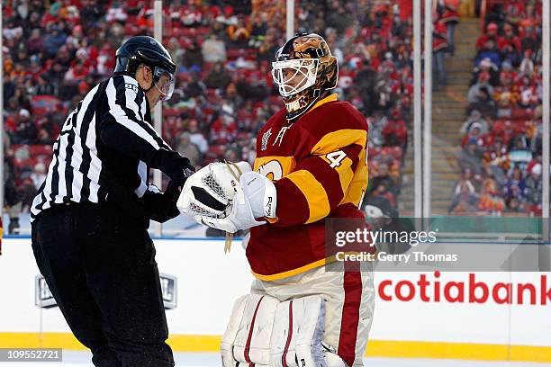 Miikka Kiprusoff of the Calgary Flames hands the puck to the referee against the Montreal Canadiens on February 20, 2011 during the 2011 Heritage...