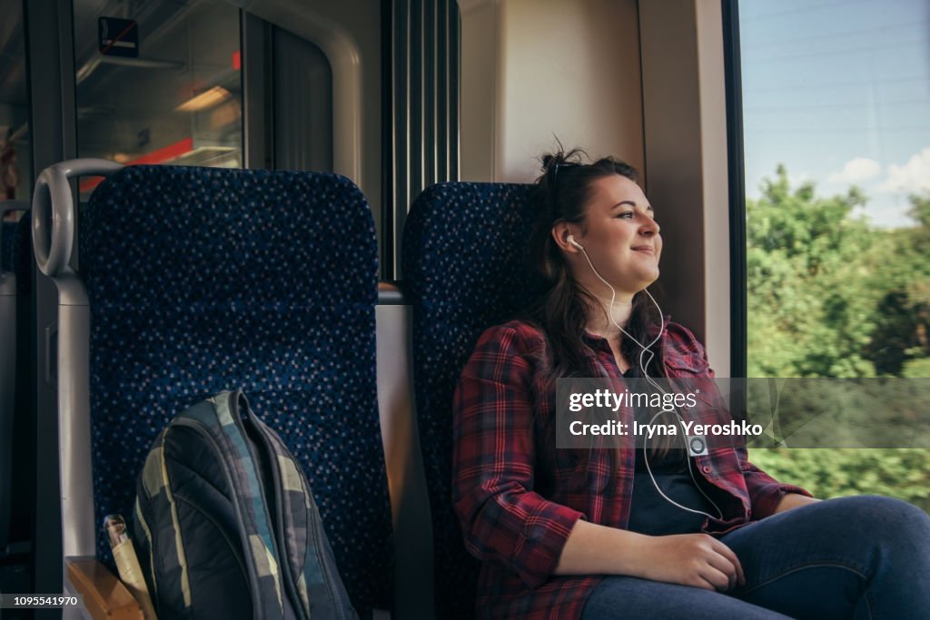 Solo traveler looks through a window on a train