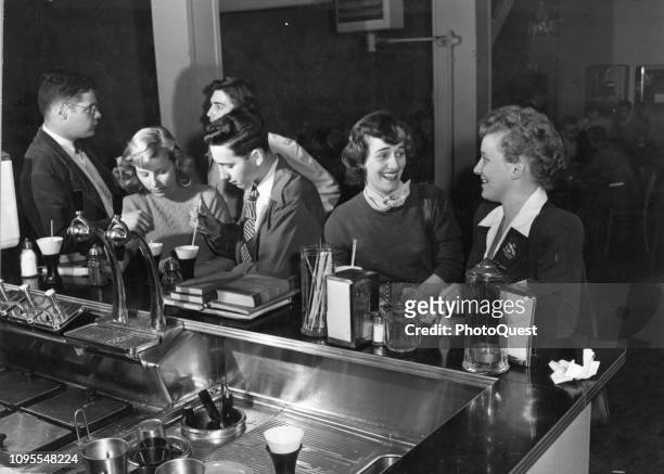 View of University of Maryland students as they sit at the counter of a soda fountain and snack bar, College Park, Maryland, 1948.