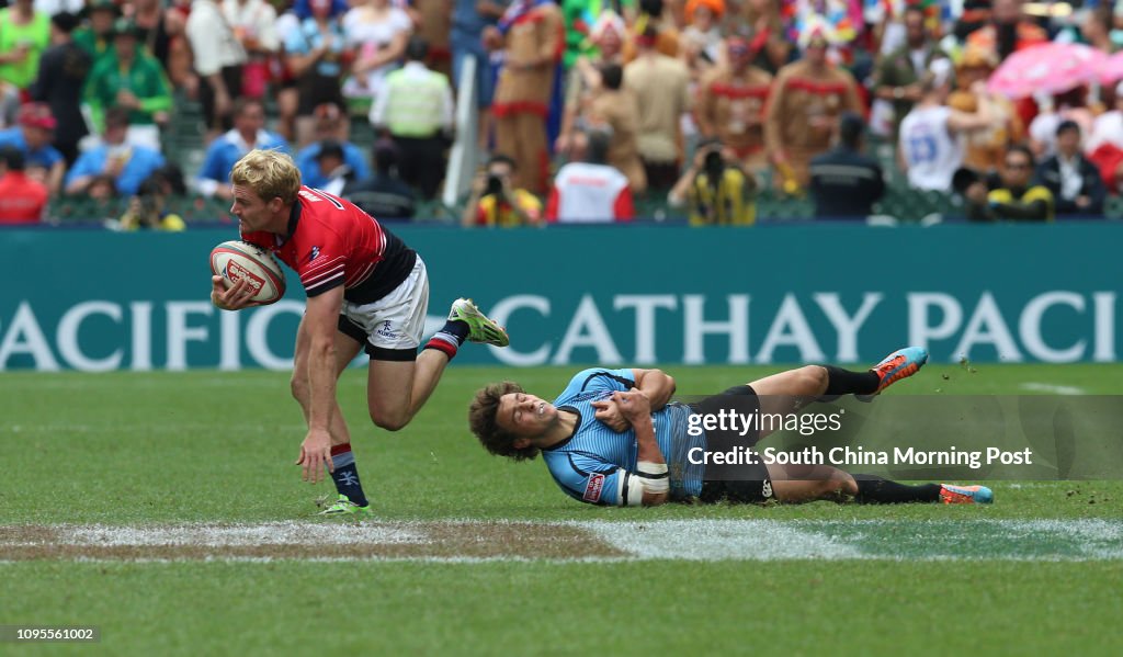 ***FOR NON-COMMERCIAL USE ONLY*** Hong Kong's Mark Wright runs out of a tackle by a Uruguay player during the 2015 Rugby Sevens tournament in Hong Kong. 28MAR15 R7