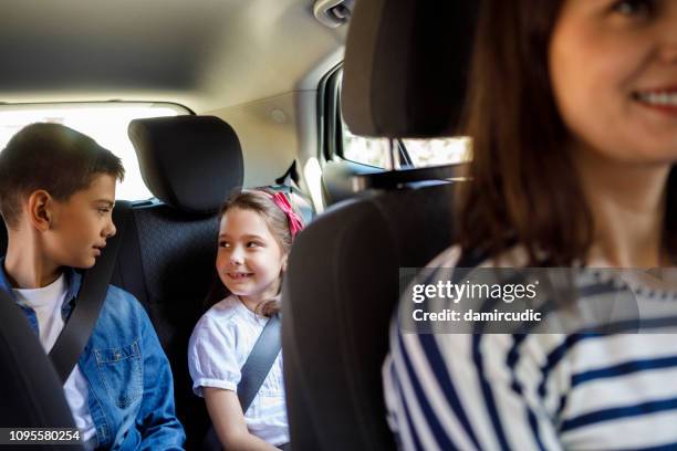 mother and her children driving in the car together - boy playing with cars stock pictures, royalty-free photos & images