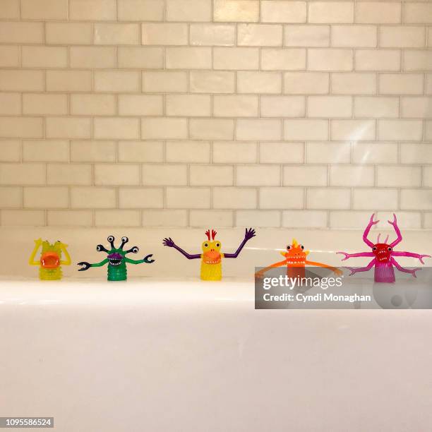 tiny monster finger puppet toys lined up in a row - finger puppet stock pictures, royalty-free photos & images