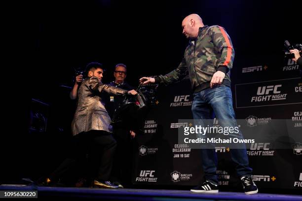 Dana White hands TJ Dillashaw's gift to Henry Cejudo during the press conference ahead of UFC Fight Night Cejudo v Dillashaw at the Music Hall of...