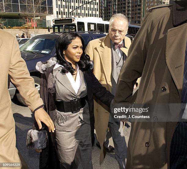 Rap star Lil' Kim, whose real name is Kimberly Jones, flanked by her legal team and fans, enters Manhattan federal court, Monday, March 14 in New...