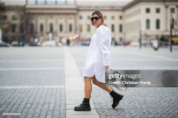 Aylin Koenig is seen wearing white dress Calvin Klein 205W39NYC, Dior saddle bag, Dior sunglasses, Dr Martens boots during the Berlin Fashion Week...