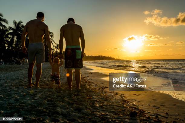 homosexual godparents and their young nephew - cuba beach stock pictures, royalty-free photos & images