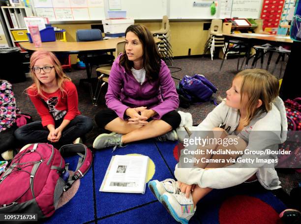 Lily Pate, left and Madeline Smith listen to teacher Mishel Reilly, center, talk about positive body image during a Girls on the Run of the Rockies...