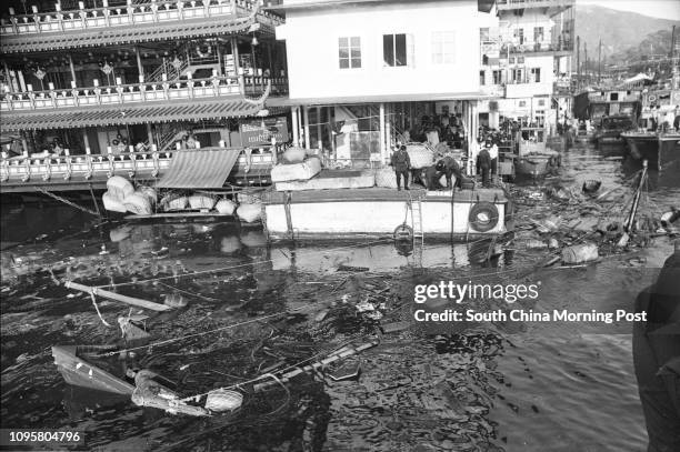 Firemen on a barge attached to the Jumbo Floating Restaurant survey the remains of a 70-foot trawler which exploded and sank within yards of the...