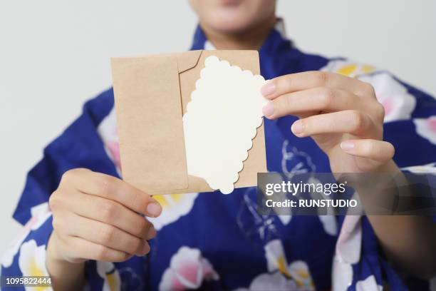 woman showing envelope and card - build presents suits photos et images de collection