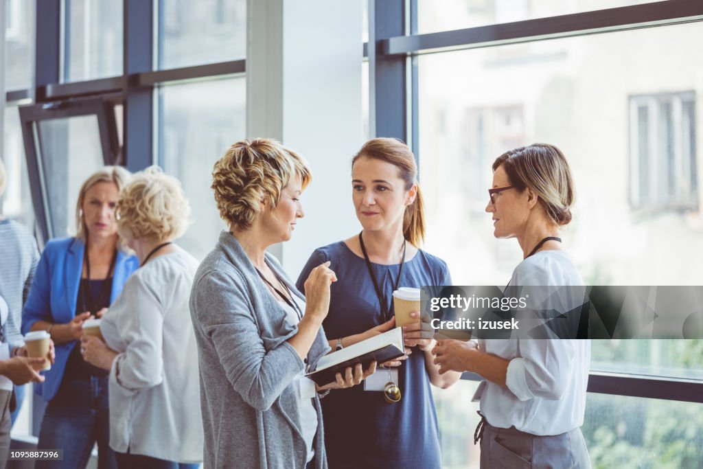 Donne che parlano durante la pausa caffè al convention center