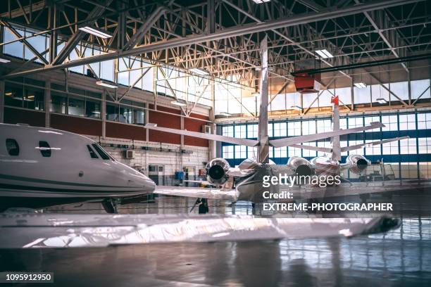 kleine vliegtuigen van de dual-motor opgeslagen in een loods van vliegtuigen - hangar stockfoto's en -beelden