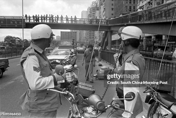 Traffic policemen inspecting the wreckage of a car on Waterfront Road after it collided with a motorcycle. 04MAY77