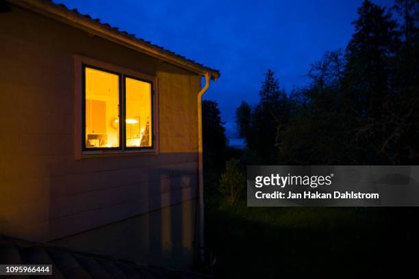 illuminated cottage window at night - garden night photos et images de collection