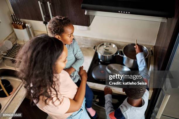 getting his first taste of cooking - family small kitchen stock pictures, royalty-free photos & images