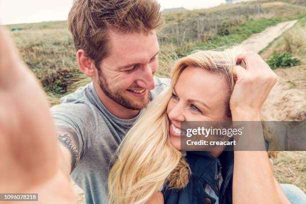pov ein glückliches paar, wobei eine selfie oben fistral beach, newquay, cornwall - nordeuropäischer abstammung stock-fotos und bilder