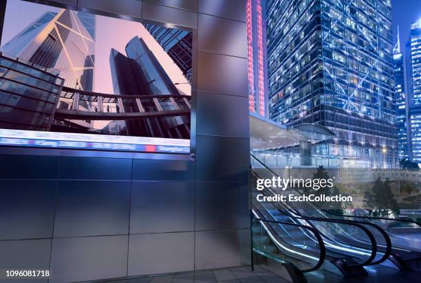 business district with large billboard display at dusk - billboard night photos et images de collection