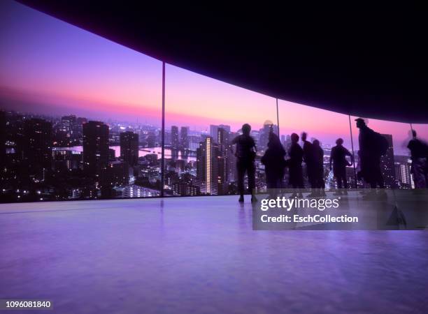 people watching projection of the tokyo skyline on a large screen - projectieapparatuur stockfoto's en -beelden