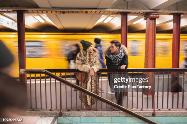 jong (echt) paar wachten op hun trein en chatten - man woman train station stockfoto's en -beelden